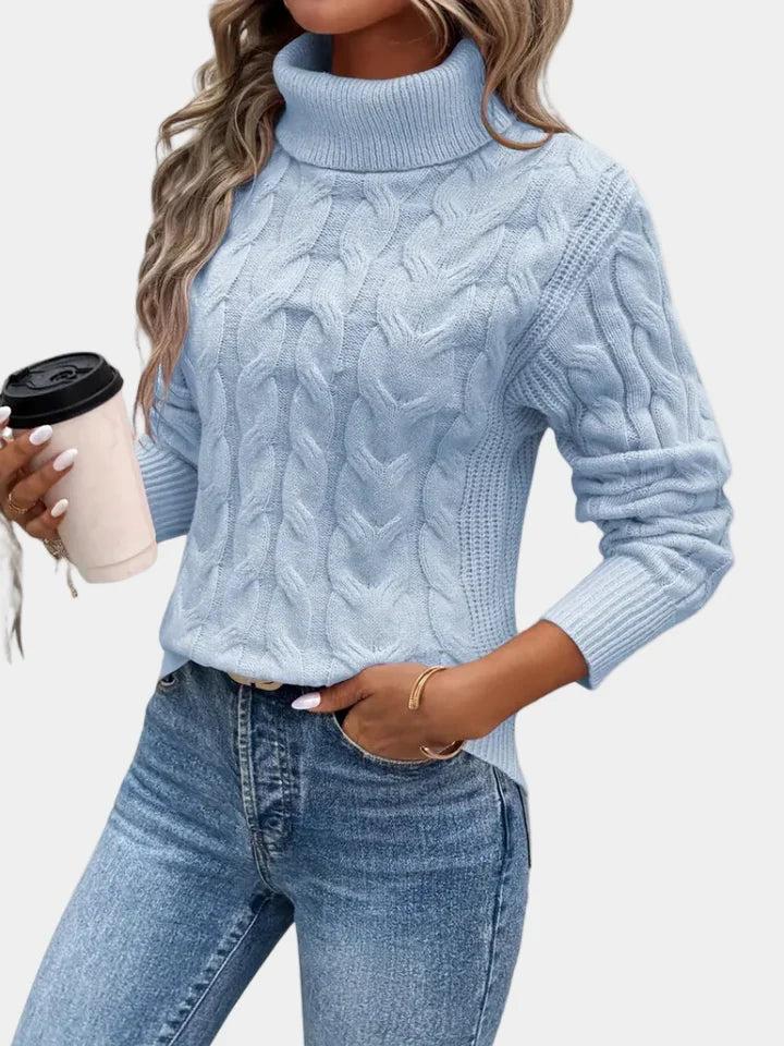 Cora Women’s Sweater featuring a stylish cable knit design and a cozy high turtleneck collar, perfect for fall and winter layering. 1
